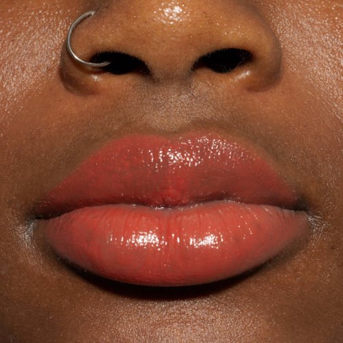 Nahaufnahme von Lippen mit glänzender pinker Lippenstift und Nasenpiercing.