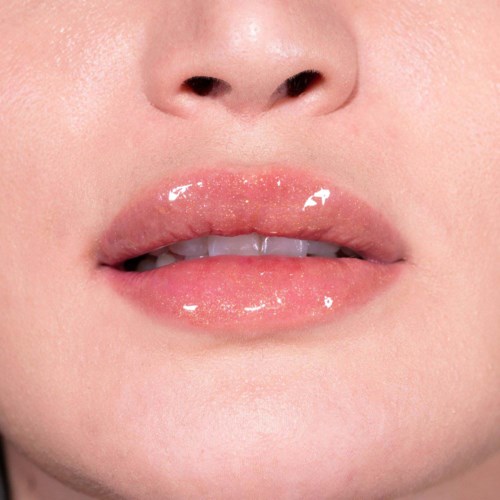Nahaufnahme von leicht geöffneten Lippen mit glänzender, feuchter Haut und sichtbaren kleinen Zähnen.