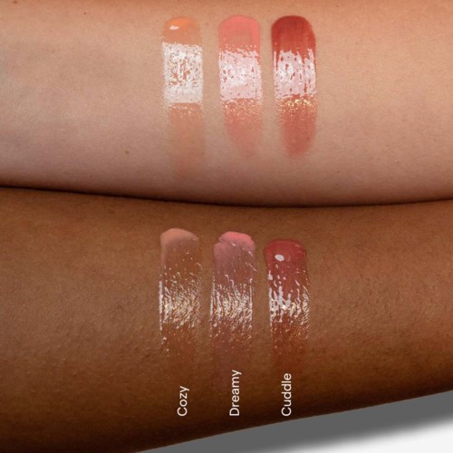 Proben von drei verschiedenen Lippenstiftfarben mit den Namen Cozy, Dreamy und Cuddle auf zwei Hauttönen. Jede hat eine obere und untere Spur.