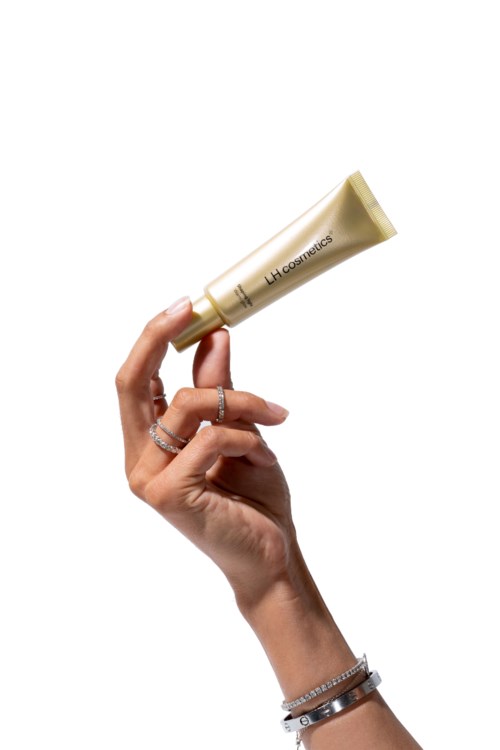 Kädessä on beige hylsy, jossa lukee "LHE Cosmetics".
