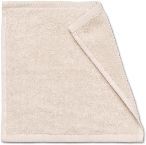 A soft cream-colored folded towel with a corner turned back to show its texture.