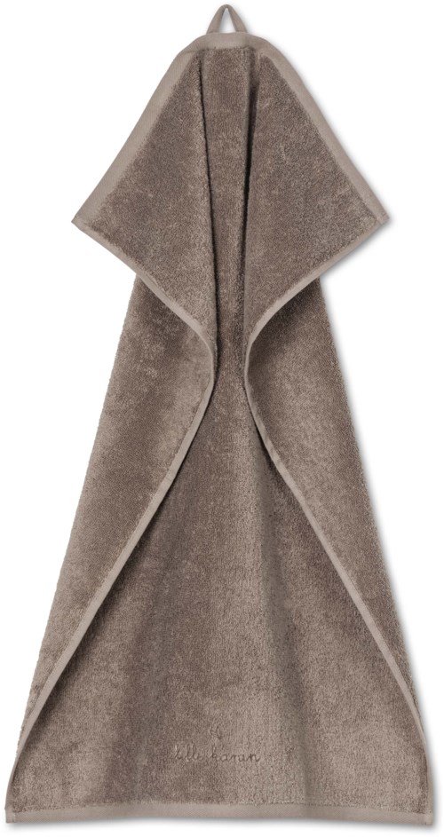 A beige soft towel hanging, with a hood at the top and edges folded. It looks warm and cozy.