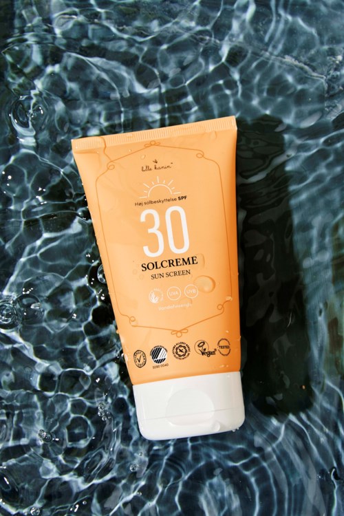 Butelka kremu przeciwsłonecznego SPF 30 unosząca się na wodzie.
