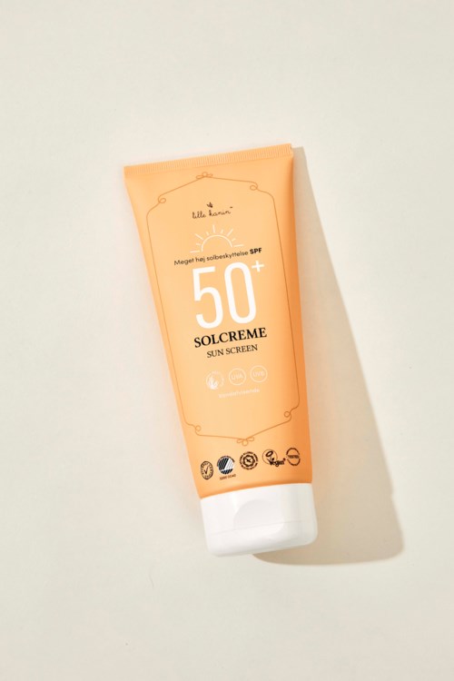 Persikan värinen aur Кремi SPF 50+ tippa valkoisella taustalla.