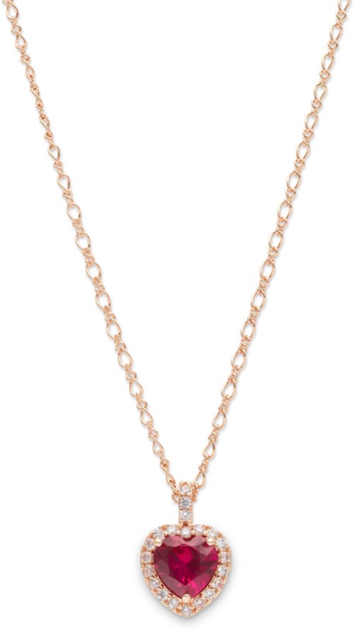 A gold chain with a heart-shaped red gemstone pendant surrounded by small clear stones.