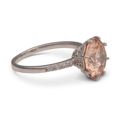 A silver ring with a large peach-colored stone and small diamonds on the band.