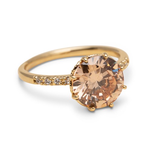 A gold ring with a large peach-colored gemstone and small diamonds on the band.