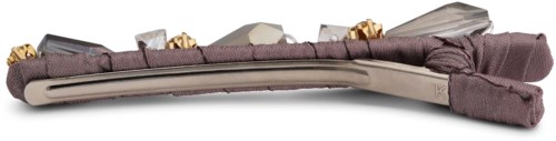 A jewelry box with a soft, padded cover, decorated with golden details and a ribbon, showing a necklace inside.