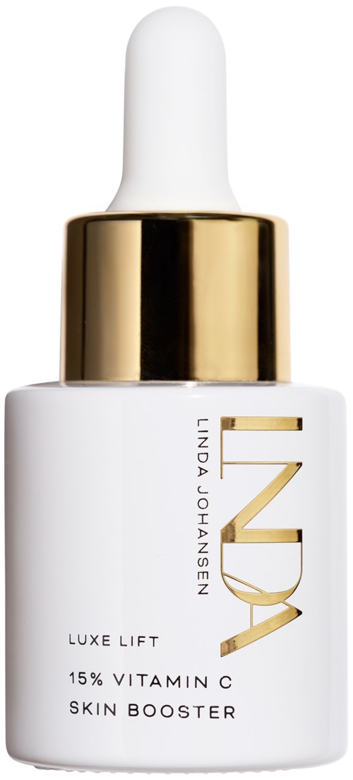 En hvit flaske med gullhette og piping, merket 'LUXE LIFT 15% VITAMIN C SKIN BOOSTER' av Linda Johansen.