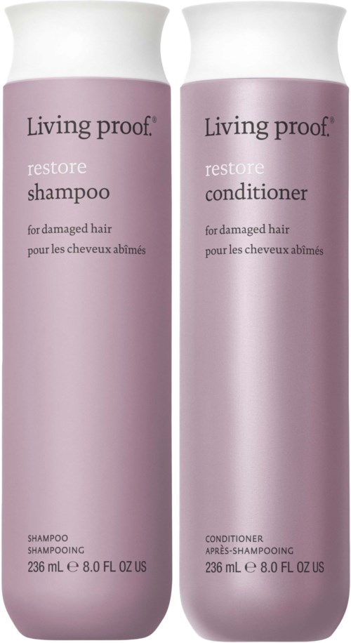 Kaksi vaalean violettista pulloa, joissa lukee 'Living proof restore shampoo ja hoitoaine' vaurioituneelle hiuksille, kumpikin 236 ml.