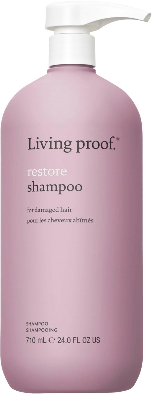 Ruusukesin värinen shampoopullo vaurioituneelle hiuksille pumpulla, merkinnällä 'Living proof restore shampoo.'