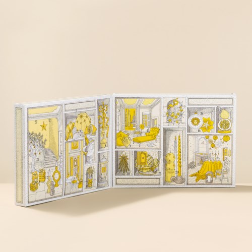 Een driedelige decoratieve doos in geel en wit met kleine objecten en patronen binnen elke sectie.