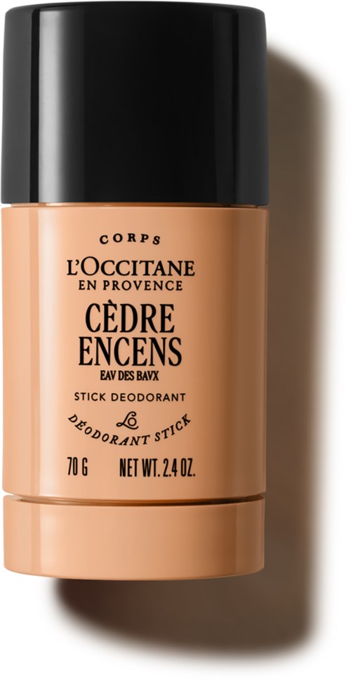 A stick deodorant bottle with black cap, beige body, and black text, labeled Cedre Encens from L'Occitane.