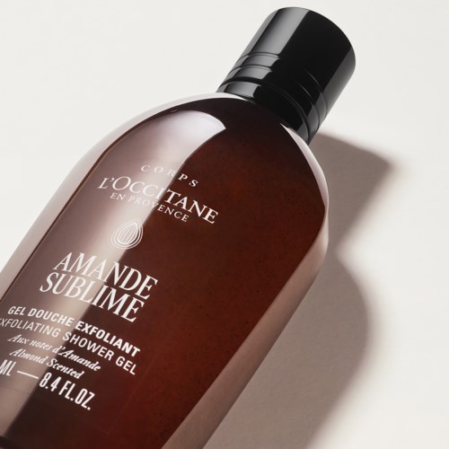 Braune Duschgel-Flasche mit schwarzem Deckel, gekennzeichnet Amande Sublime Peeling-Duschgel.