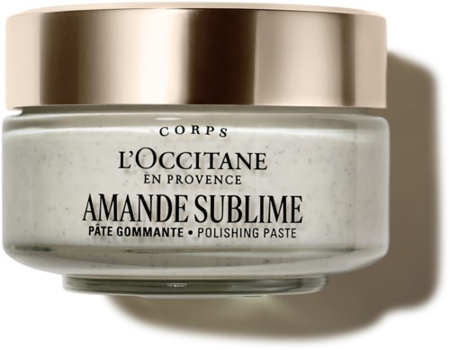 Ein Glas mit L'Occitane Amande Sublime Peelingpaste mit goldenem Deckel und weißem Körper.