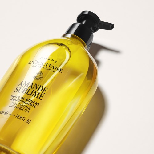L'Occitane Duschöl mit gelbem Flüssigkeit und schwarzer Pumpe, Etikett zeigt Produktdetails und Marke.