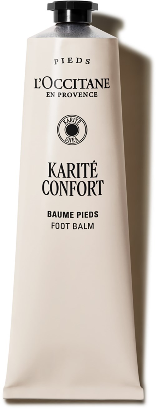 Eine weiße Tube Fußbalsam namens Karité Confort von L'Occitane mit schwarzem Verschluss, steht vertikal vor einem schattigen Hintergrund.