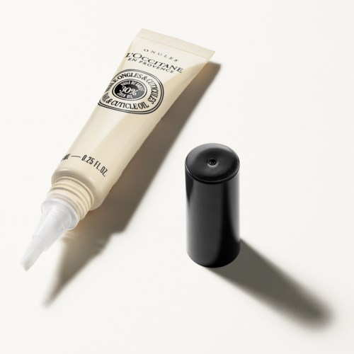 Eine weiße Tube mit L'Occitane Handcreme und einem schwarzen Deckel daneben. Schlichtes und minimalistisches Design.