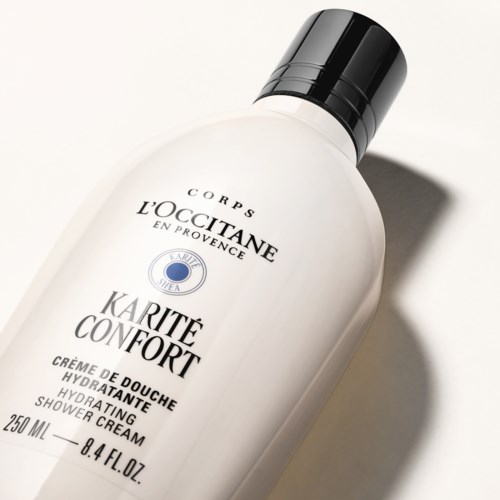 Eine weiße Duschcreme-Flasche mit schwarzem Deckel, beschriftet 'L'OCCITANE Karité Confort', 250 ml, hautpflegende und komfortsteigernde Elemente.