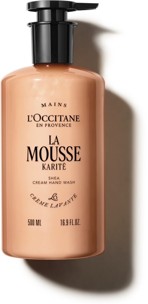 Eine rosa-beige Handseifenspenderflasche mit schwarzem Pumpkopf, beschriftet L'Occitane La Mousse Karité Shea Cream Hand Wash.