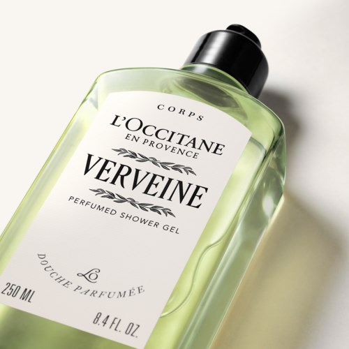 Eine Flasche Parfümiertes Duschgel von L'Occitane mit der Bezeichnung Verveine, mit durchsichtig grünem Inhalt.