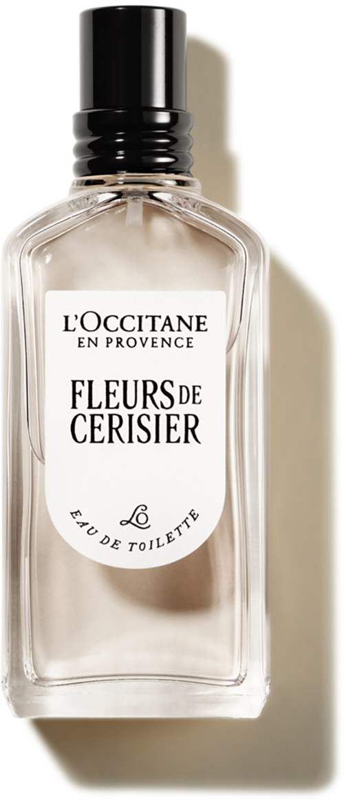 Eine klare Parfümflasche mit schwarzem Verschluss, Etikett sagt 'Fleurs de Cerisier,' blumiger Duft, elegantes und einfaches Design.