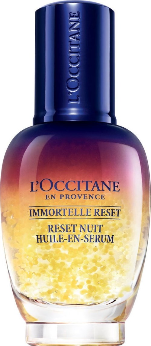 Ein Serumflasche mit dunkelblauer Kappe und Farbverlauf von Lila bis Gelb, beschriftet "L'OCCITANE IMMORTELLE RESET."