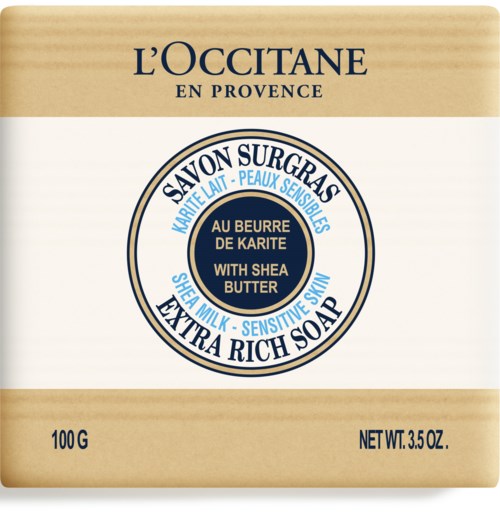 Tvål med beige och vit förpackning, blå och guld accenter, och varumärket L'Occitane. Den nämner sheasmör. Enkel design.