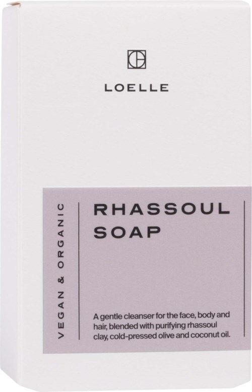 A white soap box with black and purple text, stating it is vegan and organic rhassoul soap for face, body, hair.