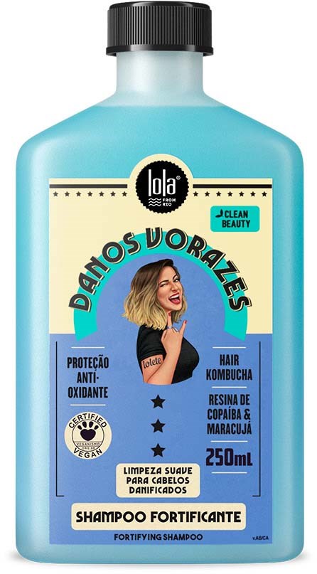 Vaaleansininen shampookori, jossa hymyilevä nainen ja mainostaa vahvistavaa shampoota vaurioituneeseen hiukseen.