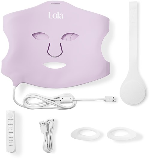 A pink face mask with eye and nose openings, a white spatula, chargers, and accessories for skincare or facial treatment.