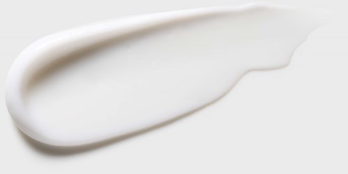 Een dot witte crème of lotion op een zwarte achtergrond.