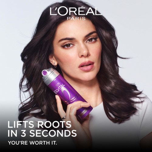 A woman with dark hair holding a purple bottle, with text about L'Oréal Paris hair product benefits.