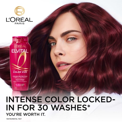 En kvinne med skinnende, rødt hår ved siden av en rosa flaske med hårfarge fra L'Oréal Paris. Teksten promoterer hårfargebeskyttelse for 30 vask.