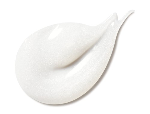 En vit kräm eller lotion med ett strukturerat, lite glittrande ytskikt, formad som en klick med spetsig topp.