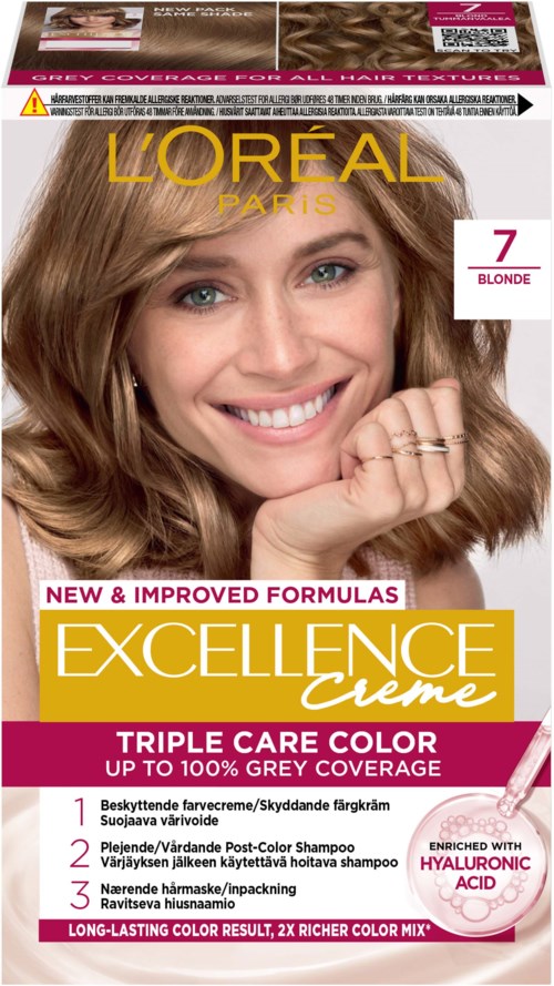 Eine Frau mit braunen Haaren, die lächelt, hält ihr Kinn, auf einer Haarfärbemittelverpackung für Blond, mit Produktdetails.