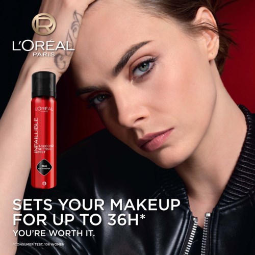 Eine Frau mit hellblauen Augen und dunklen Haaren hält den Kopf. L'Oréal Paris-Logo und ein roter Make-up-Spray sind sichtbar.