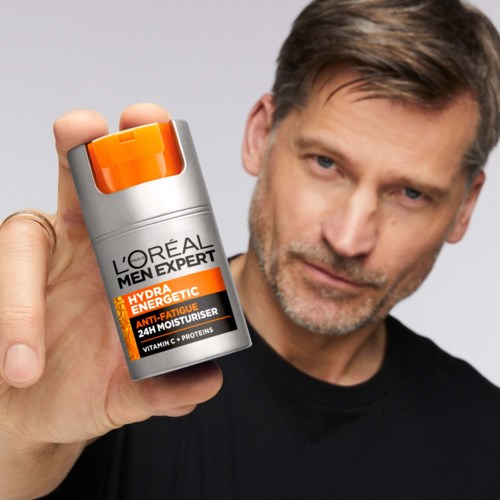 Ein Mann hält eine Flasche L'Oreal Men Expert Hydra Energetic Anti-Fatigue Moisturizer.
