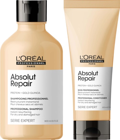 Two beige hair care products labeled 'Absolut Repair' from L'Oréal, one shampoo and one conditioner, for damaged hair.