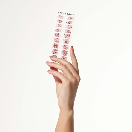 A hand holds a sheet with red lipstick stains and the phrase "LOVE'N LAYER" at the top.