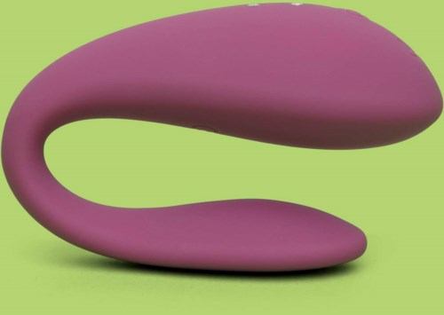 Ein pinker, gebogener Gegenstand mit zwei abgerundeten Enden auf grünem Hintergrund.
