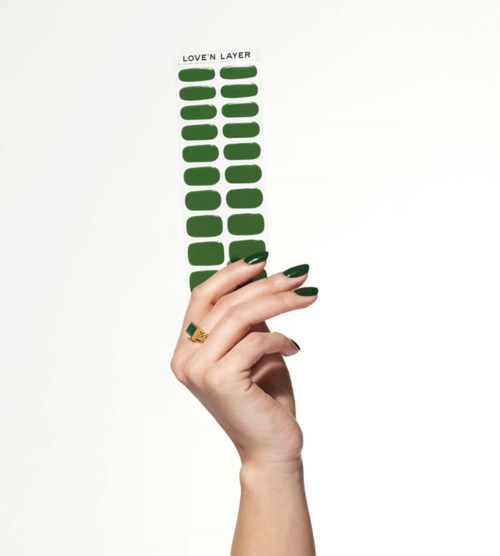 A hand holds a green sticker strip with the words 'LOVE'N LAYER' at the top.