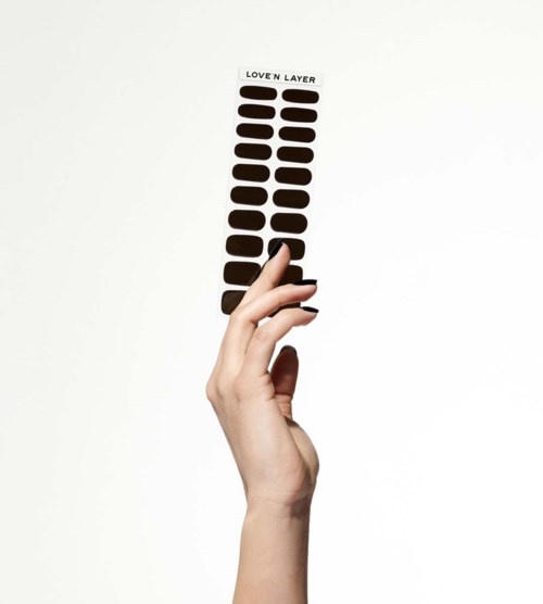 A hand holds a strip of dark brown stickers labeled "LOVEN LAYER."