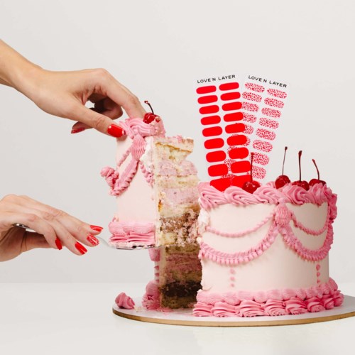 A pink layered cake with cherries, decorated with ribbons and love layer color samples next to it.
