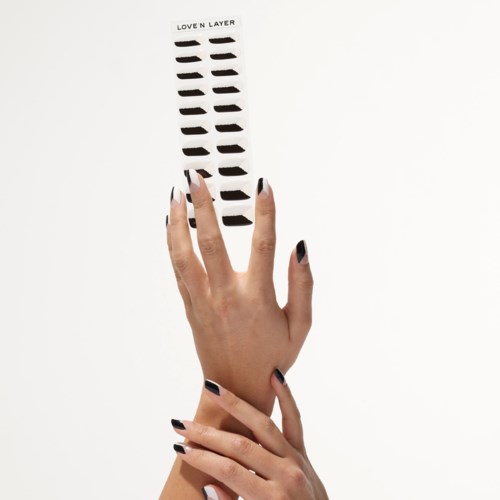 A hand holds a black sticker sheet labeled "Love N Layer" against a white background.