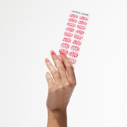A hand holds a sheet with red wavy patterns and the words 'LOVEN LAYER' at the top.
