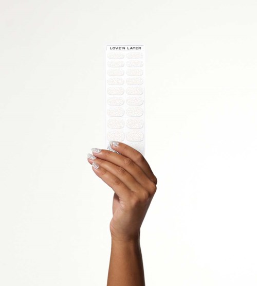 A hand holds a long strip with the text "LOVE 'N LAYER" and small empty bubbles for labeling.