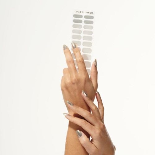 A hand holds a nail sample strip with different shades labeled 'Loven Layer' showing variety of nail colors.