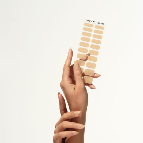 A hand holds a strip of beige shades labeled 'Lover Layer' with multiple small color samples.
