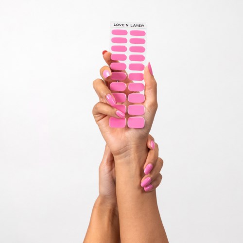 Hand holding pink nail chart with 'Love'n Layer' at top, showing different nail shapes and sizes.